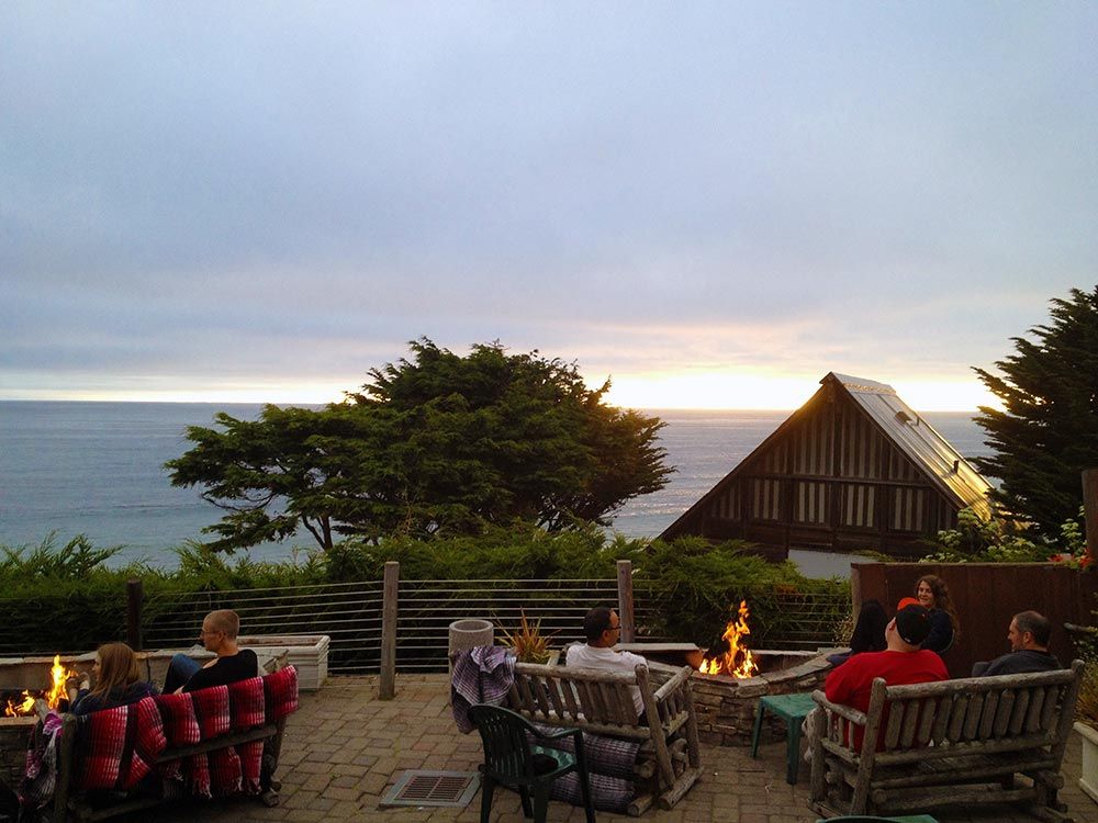 ocean view patio dining with fire pits at dusk